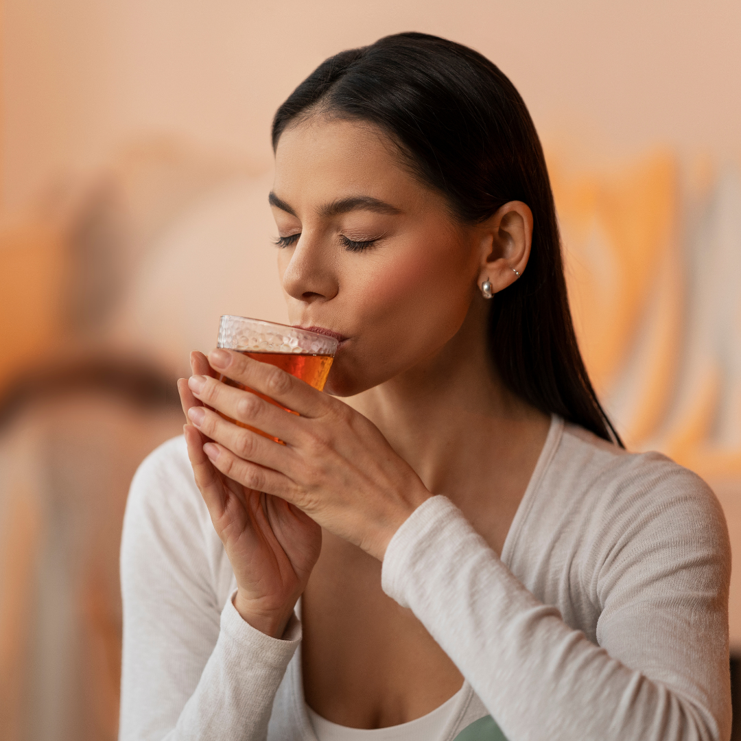 Person drinking a herbal mix for gut health, bloating, and acidity relief